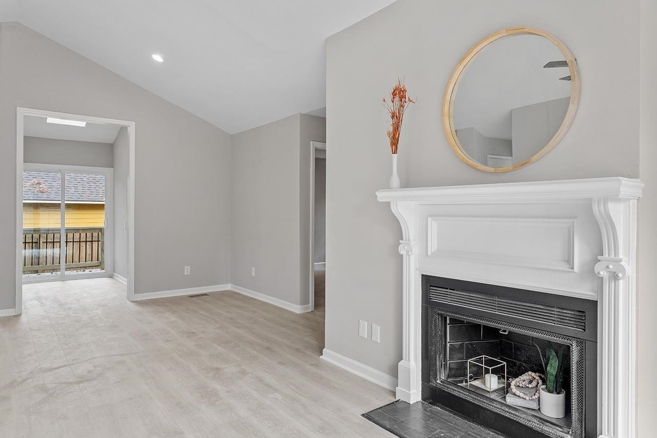 2316 Calvert Drive Raleigh, NC 27610 - Photo 14 of 34 a living room with a fireplace and a wooden floor