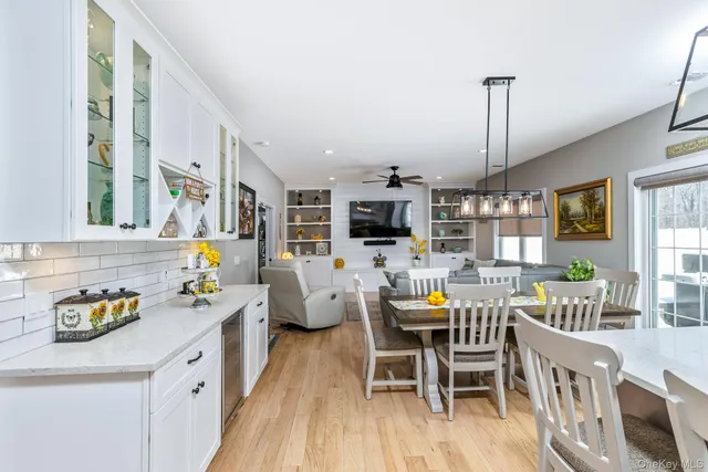 a view of a dining room and livingroom with furniture wooden floor a chandelier