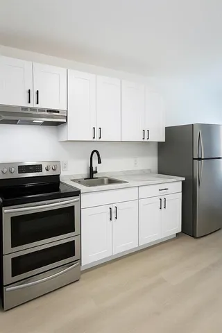 a kitchen with cabinets appliances and a sink