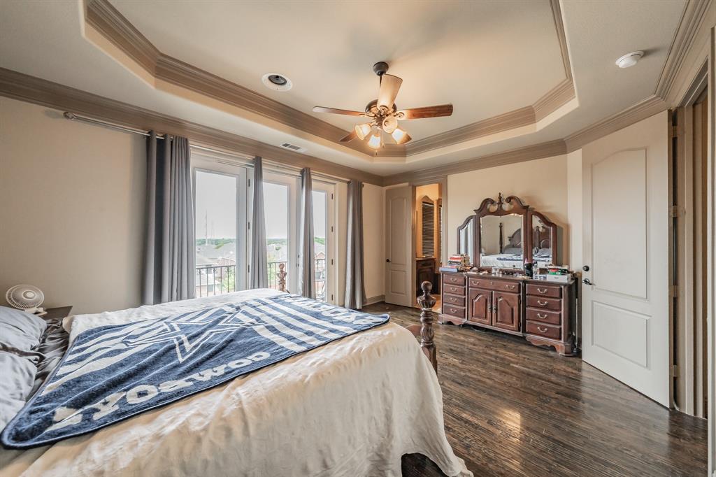 575 Rockingham Drive Irving, TX 75063 - Photo 20 of 38 a bedroom with a bed ceiling fan and a wooden floor