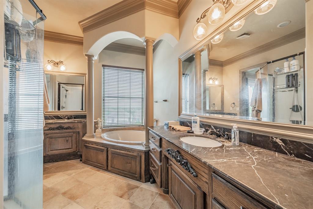 575 Rockingham Drive Irving, TX 75063 - Photo 21 of 38 a bathroom with a granite countertop sink double vanity and a bathtub