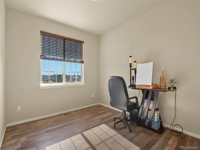 a view of a workspace with furniture and a window