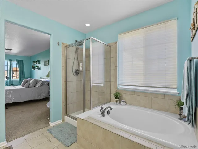 a bathroom with a tub a sink and a glass door shower