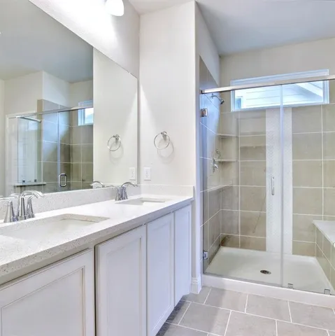 a bathroom with a shower sink and mirror