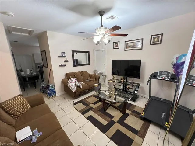 a living room with furniture a flat screen tv and a table
