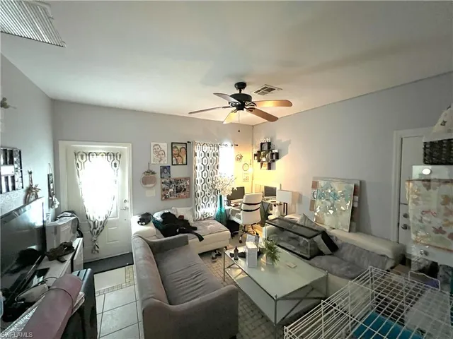 a living room with furniture a chandelier and a flat screen tv
