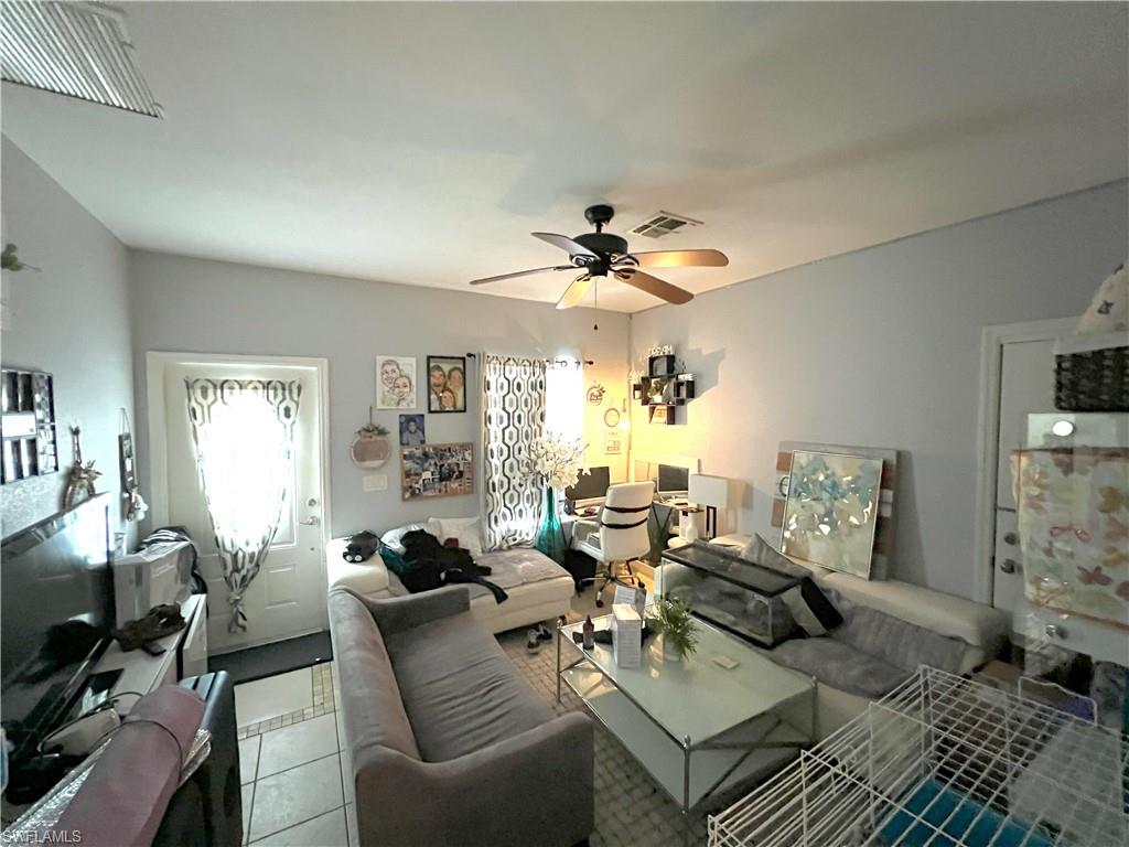 1716 48th Street Southwest Naples, FL 34116 - Photo 14 of 23 a living room with furniture a chandelier and a flat screen tv