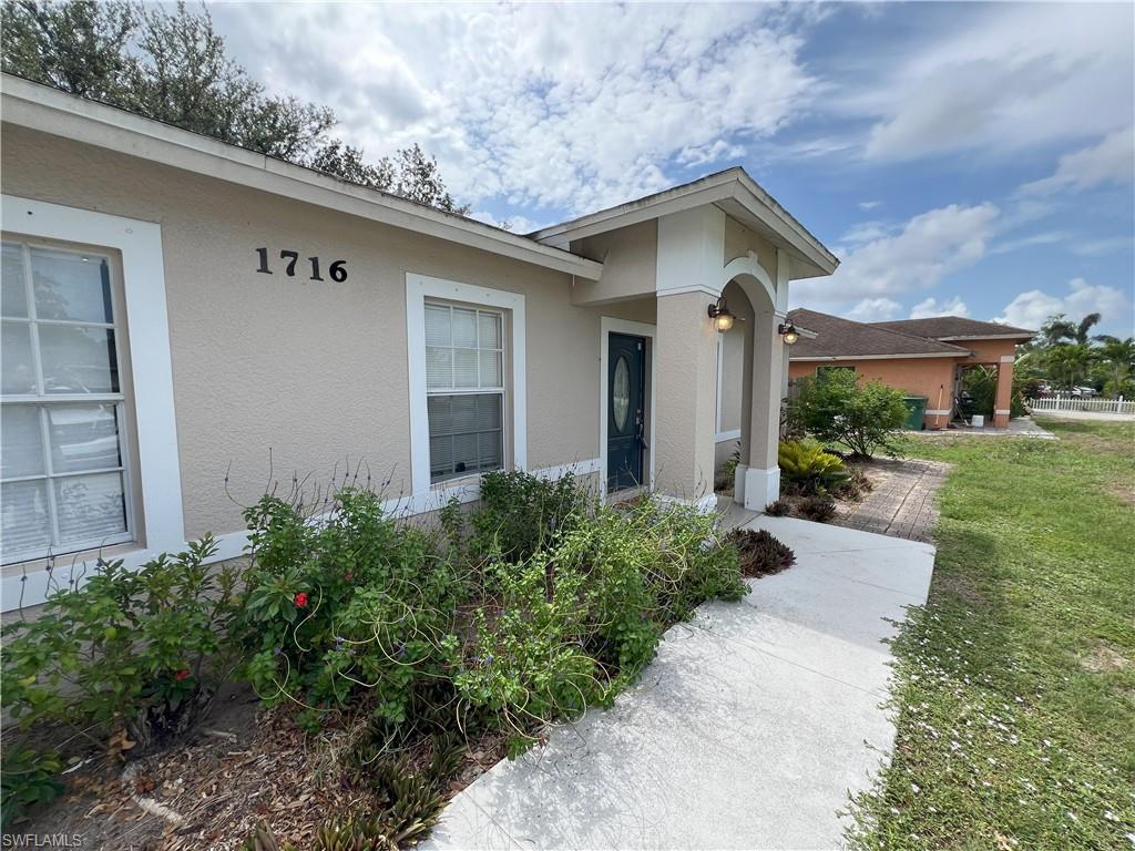 1716 48th Street Southwest Naples, FL 34116 - Photo 15 of 23 a front view of a house with garden