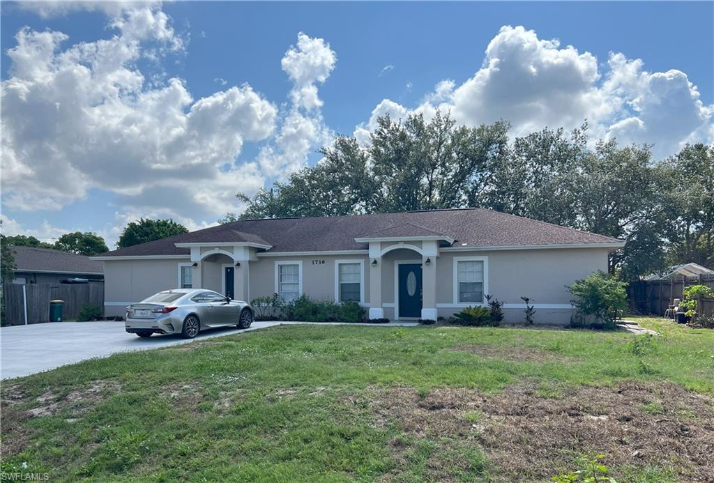 1716 48th Street Southwest Naples, FL 34116 - Photo 3 of 23 a front view of house with yard and green space