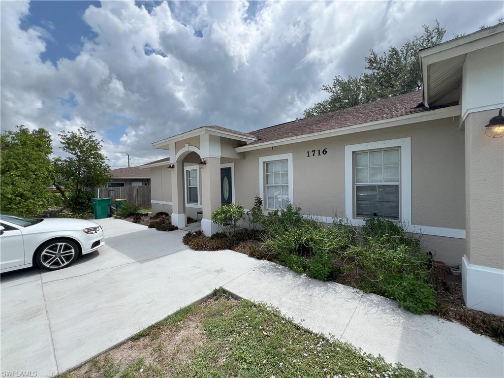 1716 48th Street Southwest Naples, FL 34116 - Photo 4 of 23 a front view of a house with a yard