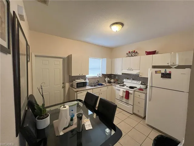 a view of a kitchen with sink and refrigerator