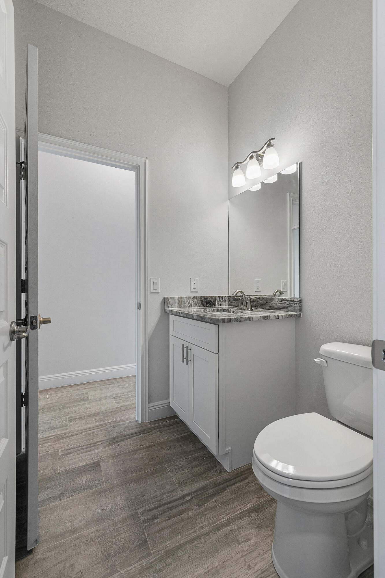 3240 Aspen Road Southeast Palm Bay, FL 32909 - Photo 8 of 12 a bathroom with a toilet a sink and mirror