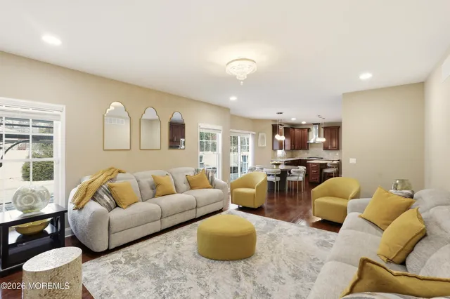 a living room with furniture kitchen view and a window