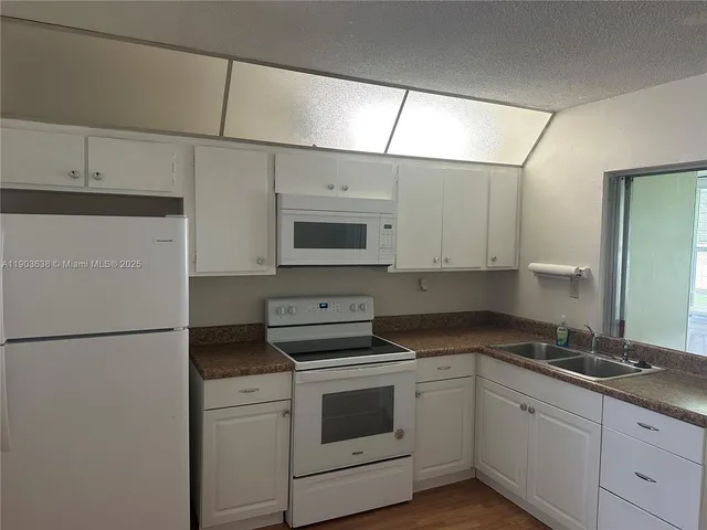 a kitchen with stainless steel appliances granite countertop white cabinets stove a sink and dishwasher