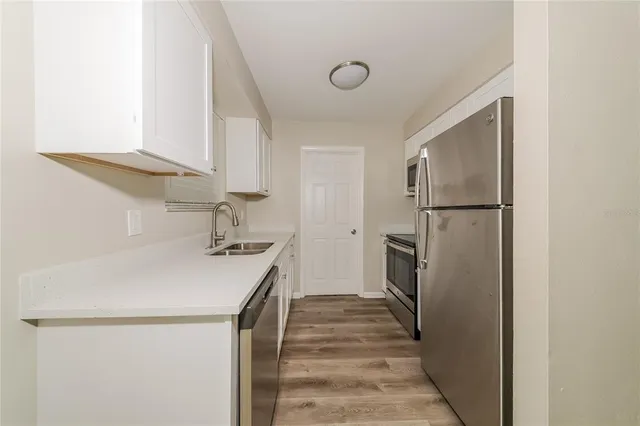 a kitchen with a sink a refrigerator and a stove
