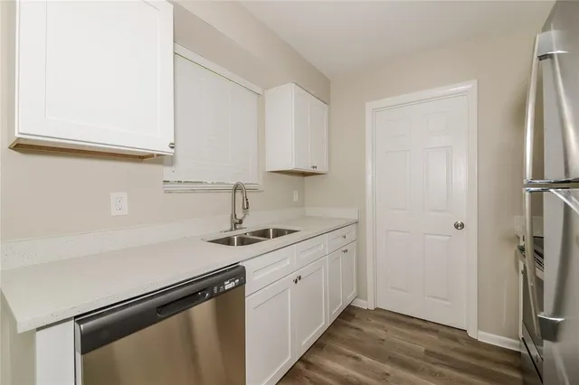 a view of a kitchen with sink and refrigerator