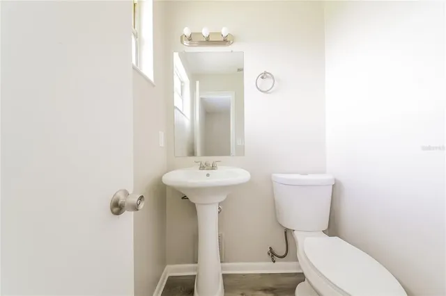a bathroom with a toilet sink and mirror