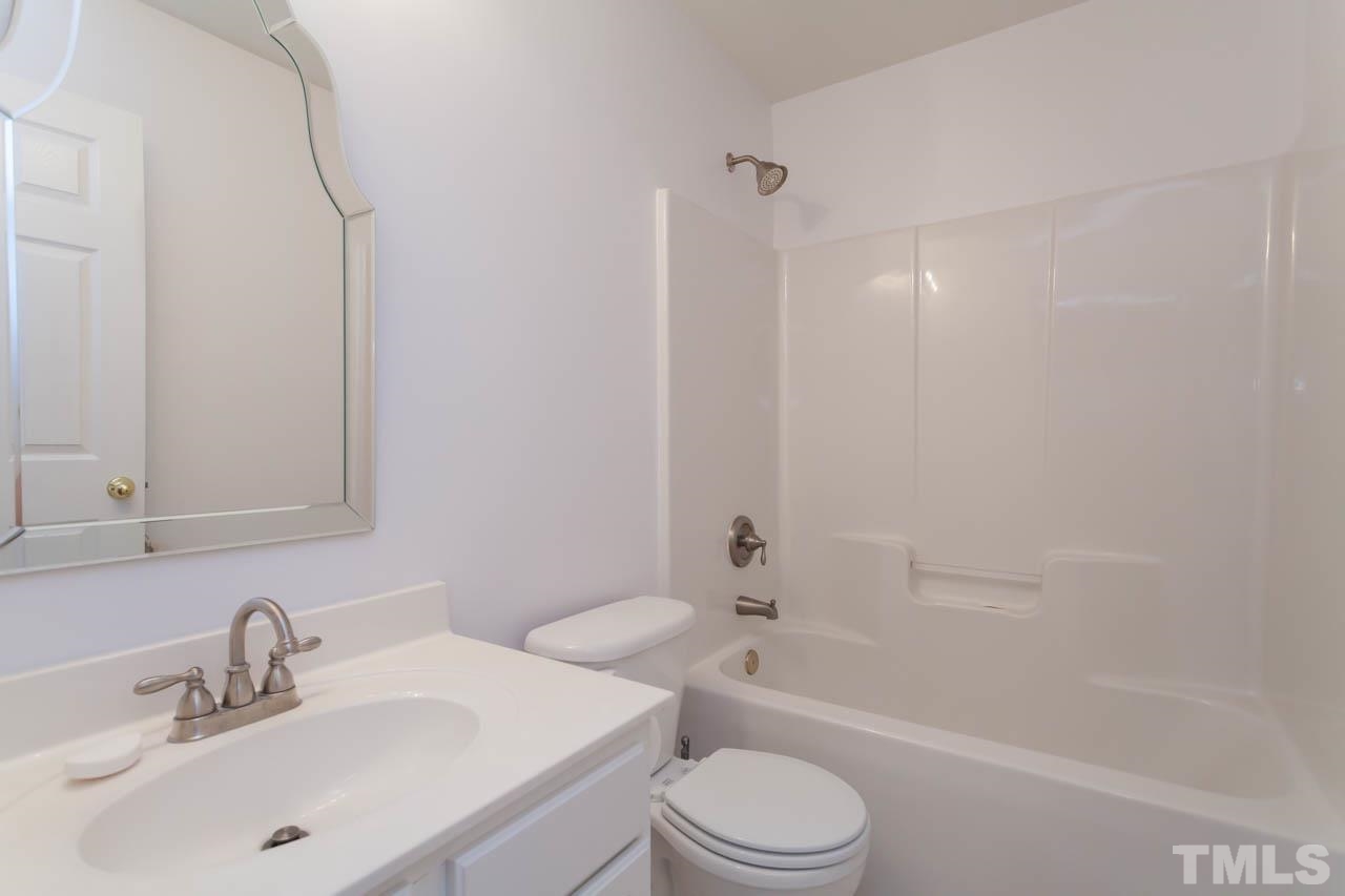 5541 Red Robin Road Raleigh, NC 27613 - Photo 13 of 23 a bathroom with a bathtub shower sink vanity mirror and toilet
