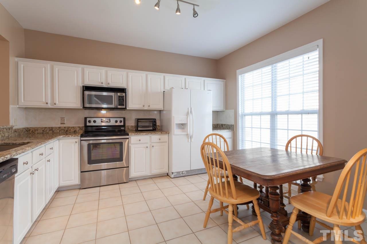 5541 Red Robin Road Raleigh, NC 27613 - Photo 5 of 23 a kitchen with granite countertop a stove a sink and a refrigerator