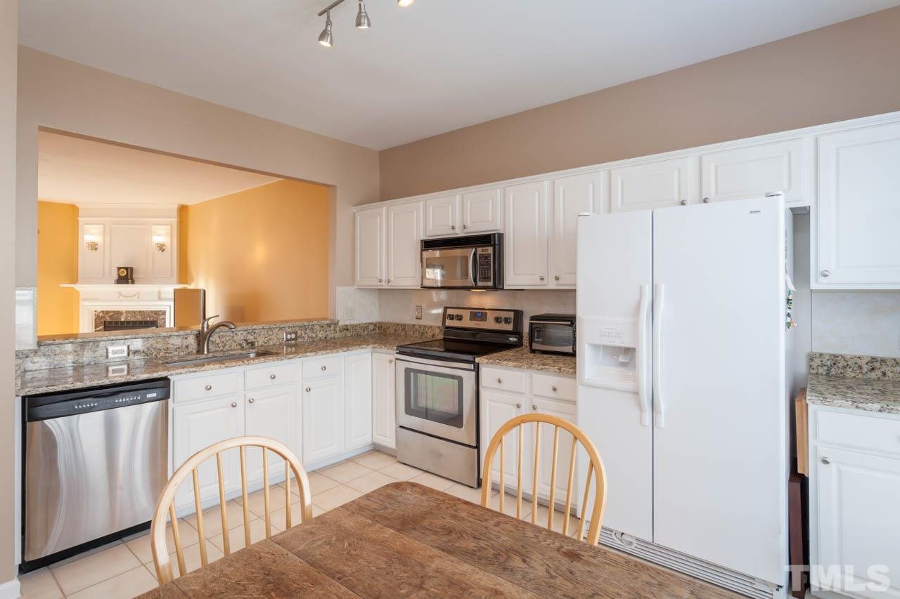 5541 Red Robin Road Raleigh, NC 27613 - Photo 6 of 23 a kitchen with stainless steel appliances granite countertop a refrigerator a stove a sink a stove and island