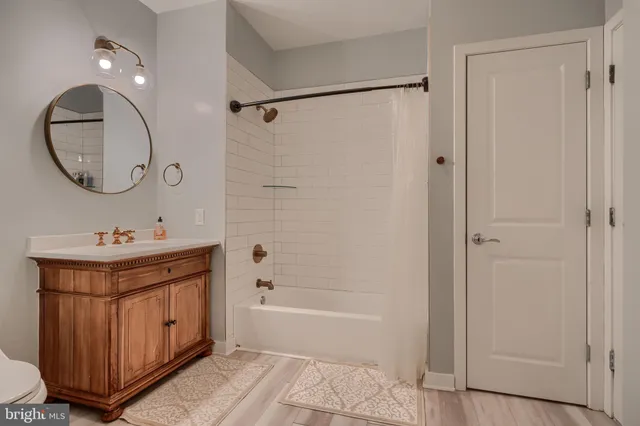a bathroom with a double vanity sink mirror and bathtub