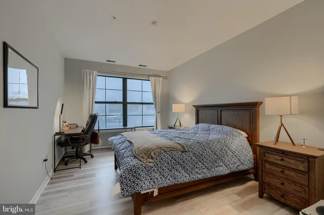 a bedroom with a bed and painting on the wall