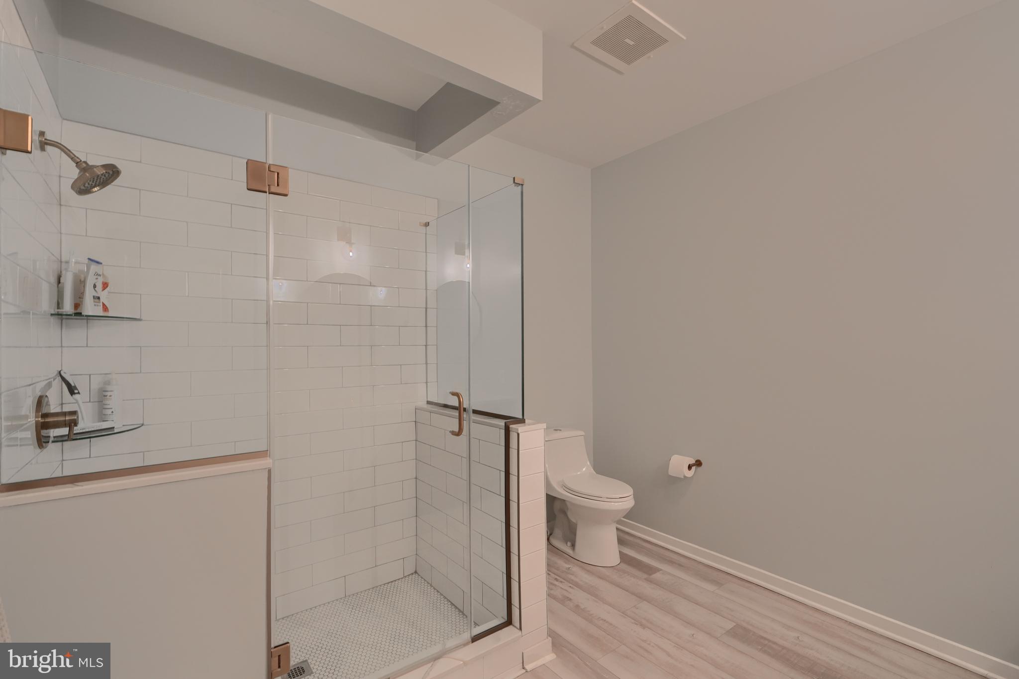 3201 St Paul Street, Unit 210 Baltimore, MD 21218 - Photo 28 of 38 a bathroom with a granite countertop toilet and a shower