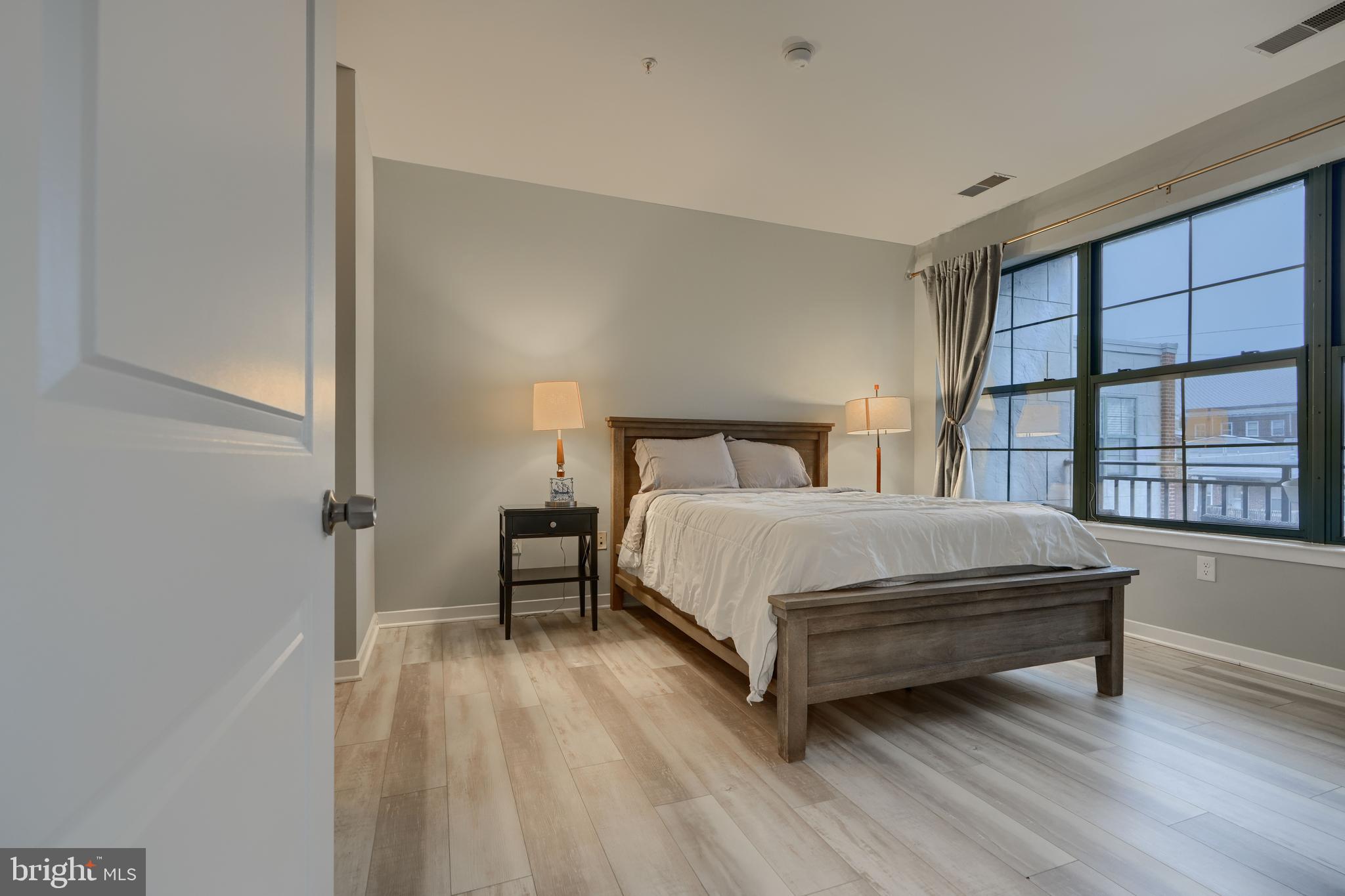 3201 St Paul Street, Unit 210 Baltimore, MD 21218 - Photo 31 of 38 a bedroom with a bed and a large window