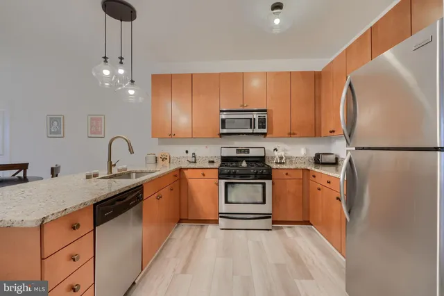 a kitchen with stainless steel appliances granite countertop a refrigerator sink and stove