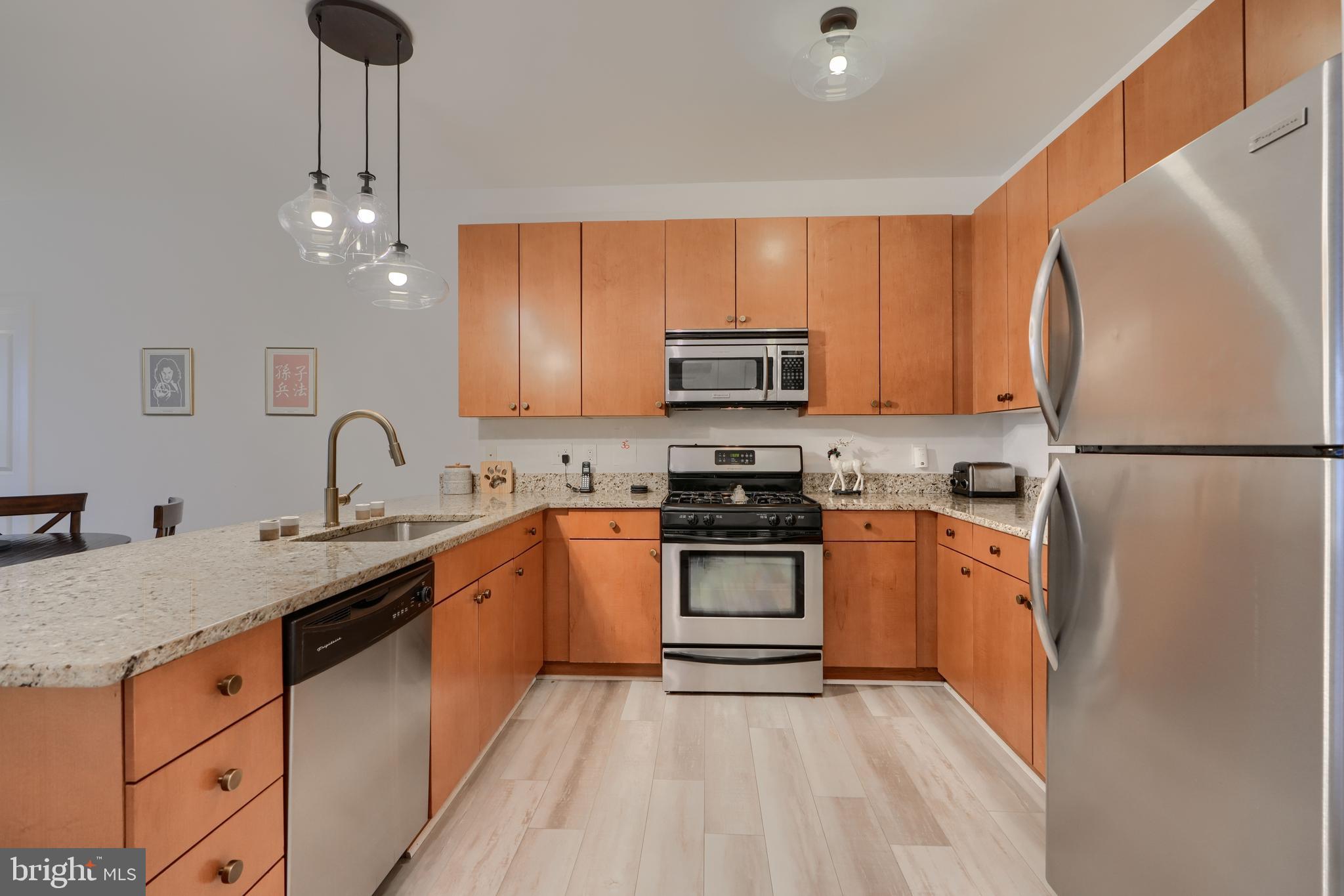 3201 St Paul Street, Unit 210 Baltimore, MD 21218 - Photo 6 of 38 a kitchen with stainless steel appliances granite countertop a refrigerator sink and stove