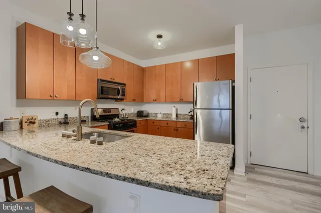 a kitchen with stainless steel appliances granite countertop a sink refrigerator and microwave
