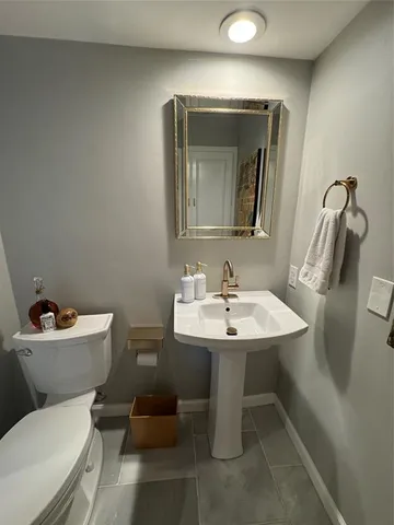 a bathroom with a toilet sink and mirror