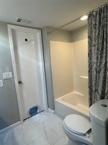 a bathroom with a shower and a toilet