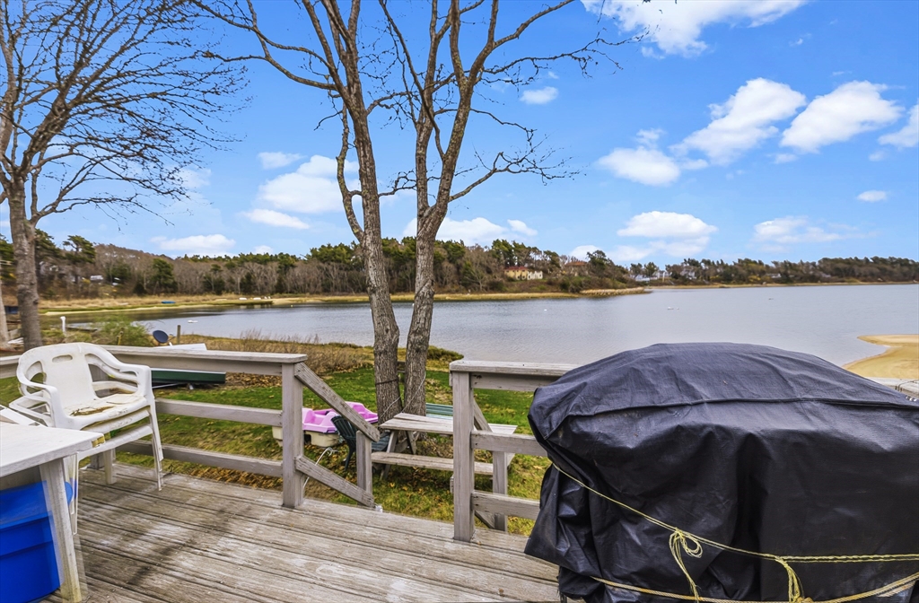 9 F Hideaway Road, Unit 11 Bourne, MA 02532 - Photo 11 of 24 a view of a lake with couches in wooden deck and lake view