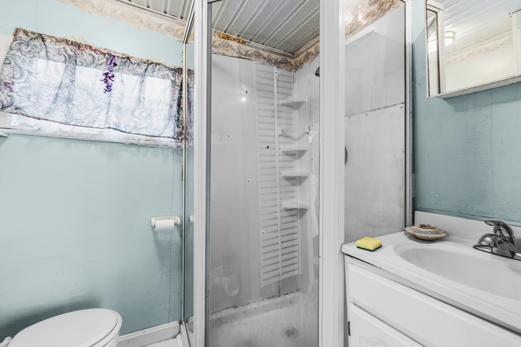 9 F Hideaway Road, Unit 11 Bourne, MA 02532 - Photo 7 of 24 a bathroom with a granite countertop sink a toilet and shower