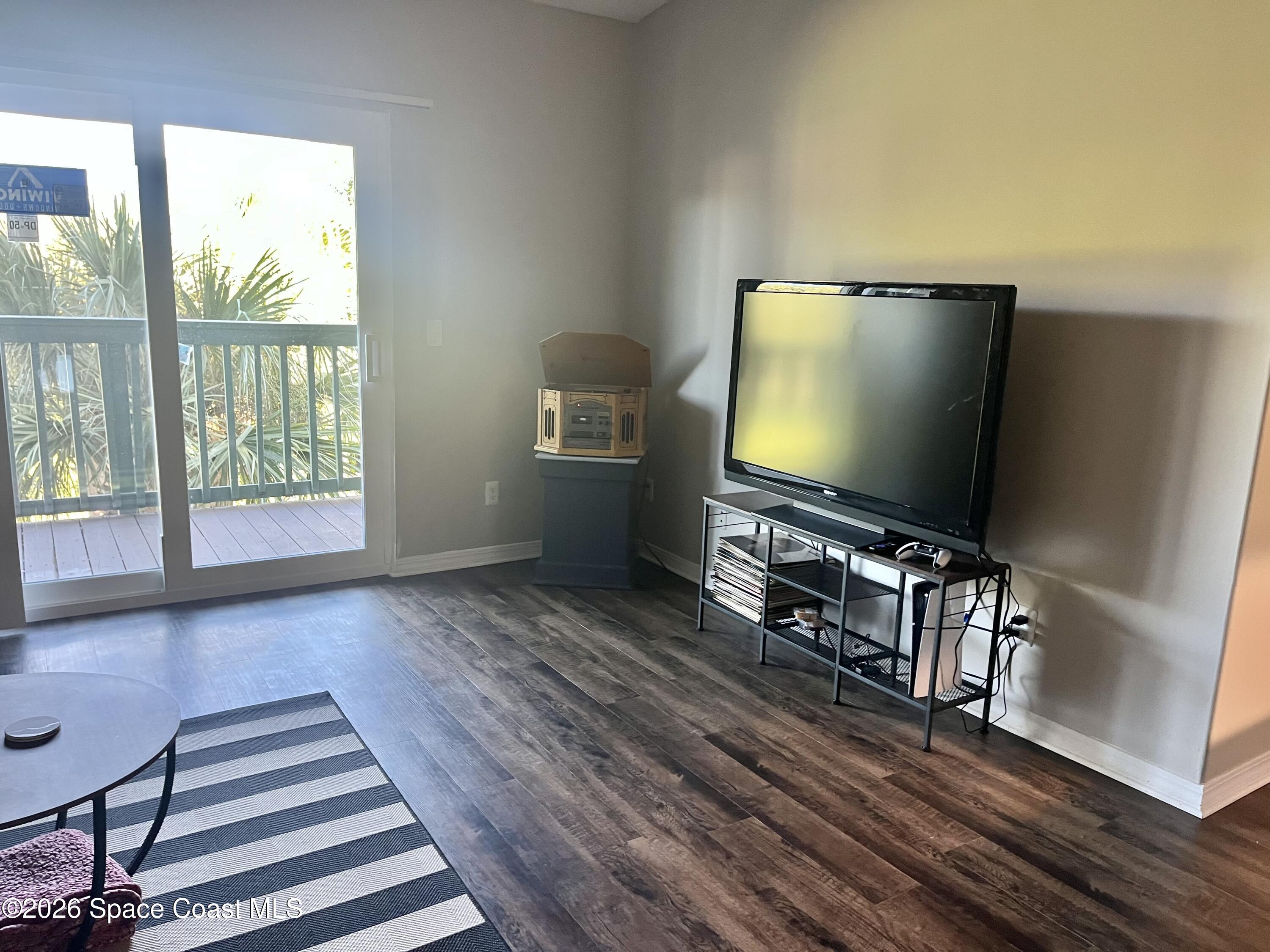 7667 North Wickham Road, Unit 1118 Melbourne, FL 32940 - Photo 7 of 26 a living room with furniture and a flat screen tv