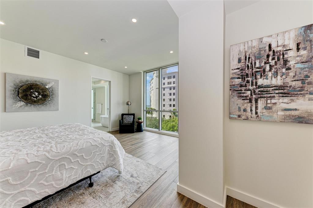111 Golden Gate Point, Unit 402 Sarasota, FL 34236 - Photo 26 of 79 a bedroom with a bed and a wall painting
