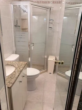 a bathroom with a granite countertop sink toilet and shower