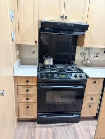 a stove top oven sitting inside of a kitchen