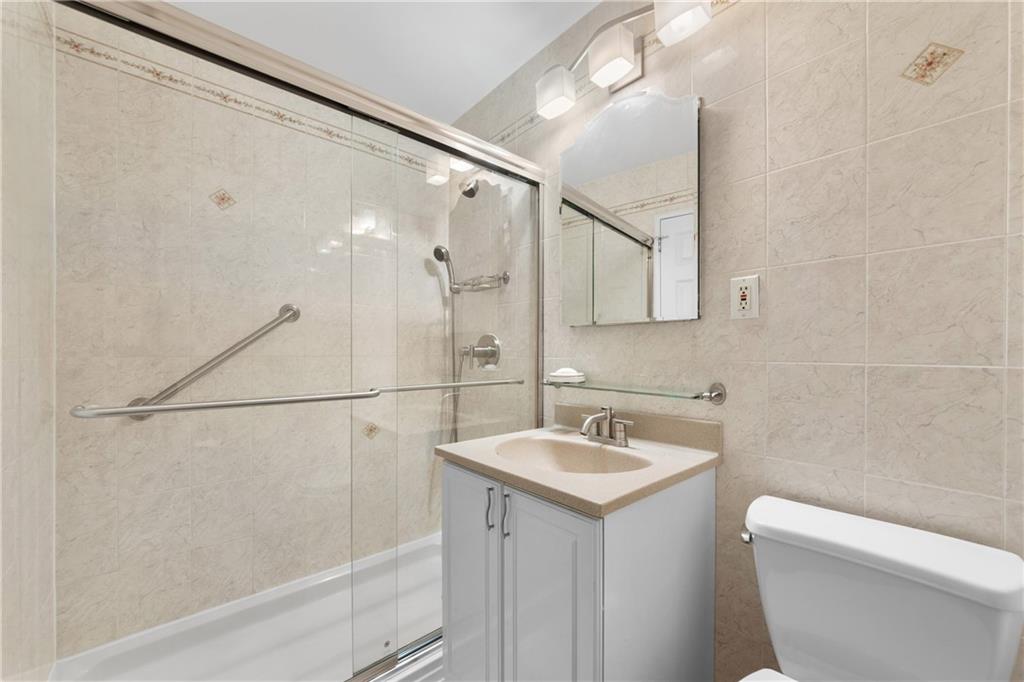 9201 Shore Road, Unit C508 Brooklyn, NY 11209 - Photo 5 of 15 a bathroom with a sink toilet and shower
