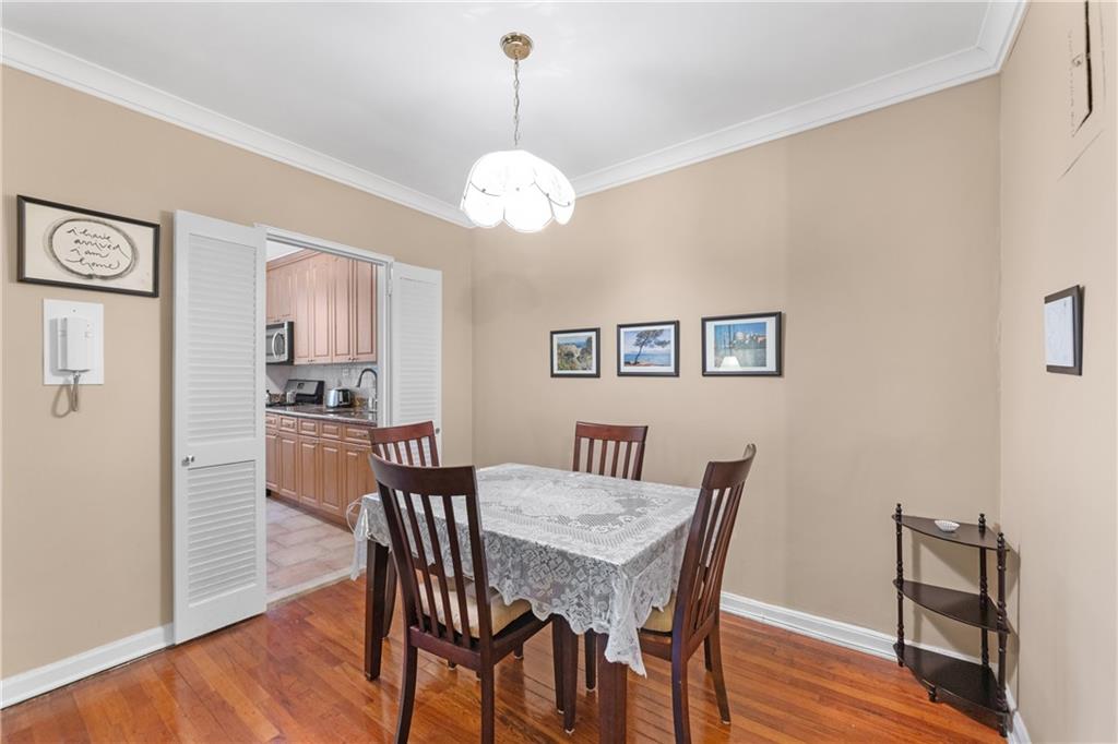 9201 Shore Road, Unit C508 Brooklyn, NY 11209 - Photo 7 of 15 a view of a dining room with furniture wooden floor and a chandelier