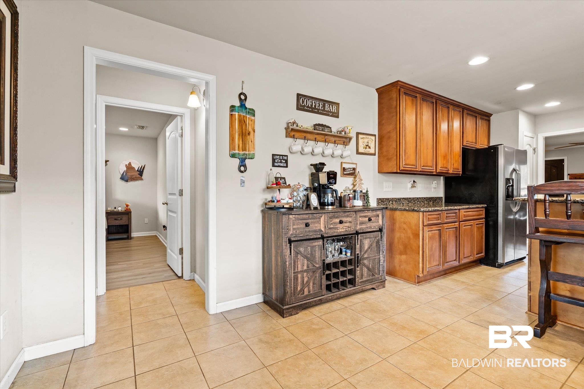 2855 Rebecca Drive West Mobile, AL 36618 - Photo 9 of 22 Kitchen featuring stainless steel fridge, dark stone countertops, and light tile patterned flooring