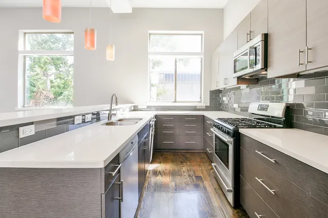 a kitchen with a sink stove top oven and refrigerator