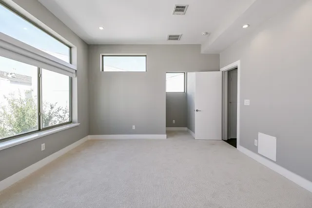 an empty room with windows and closet