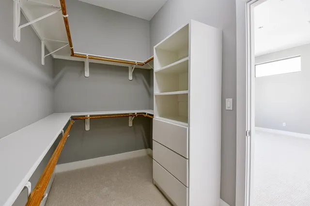 a view of walk in closet with empty racks