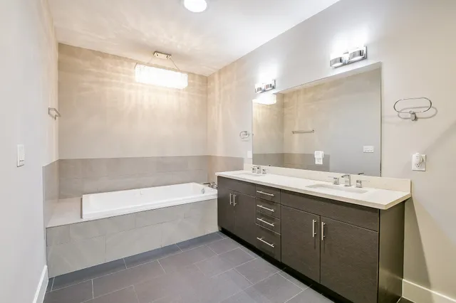 a bathroom with a tub sink and mirror