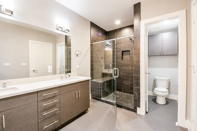 a bathroom with a double vanity sink toilet and shower