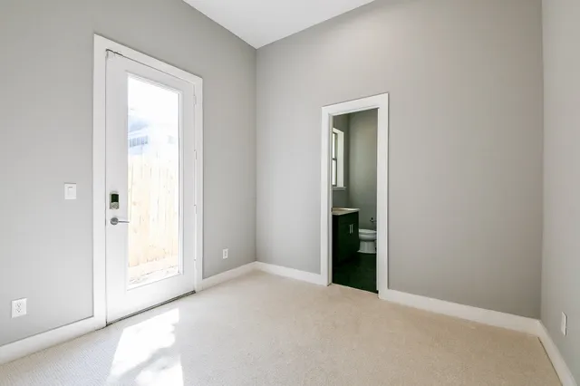 a view of an empty room with closet and a window