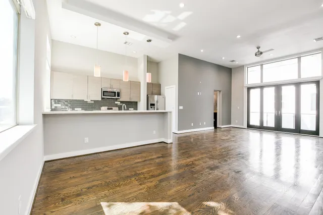 a view of a kitchen with kitchen island a sink wooden floor and counter space