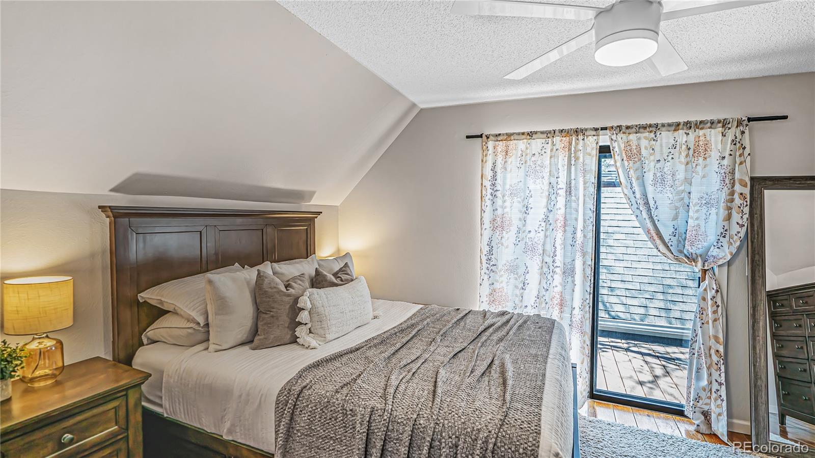 195 Brookside Drive Bailey, CO 80421 - Photo 13 of 24 a bedroom with a bed a mirror and a window